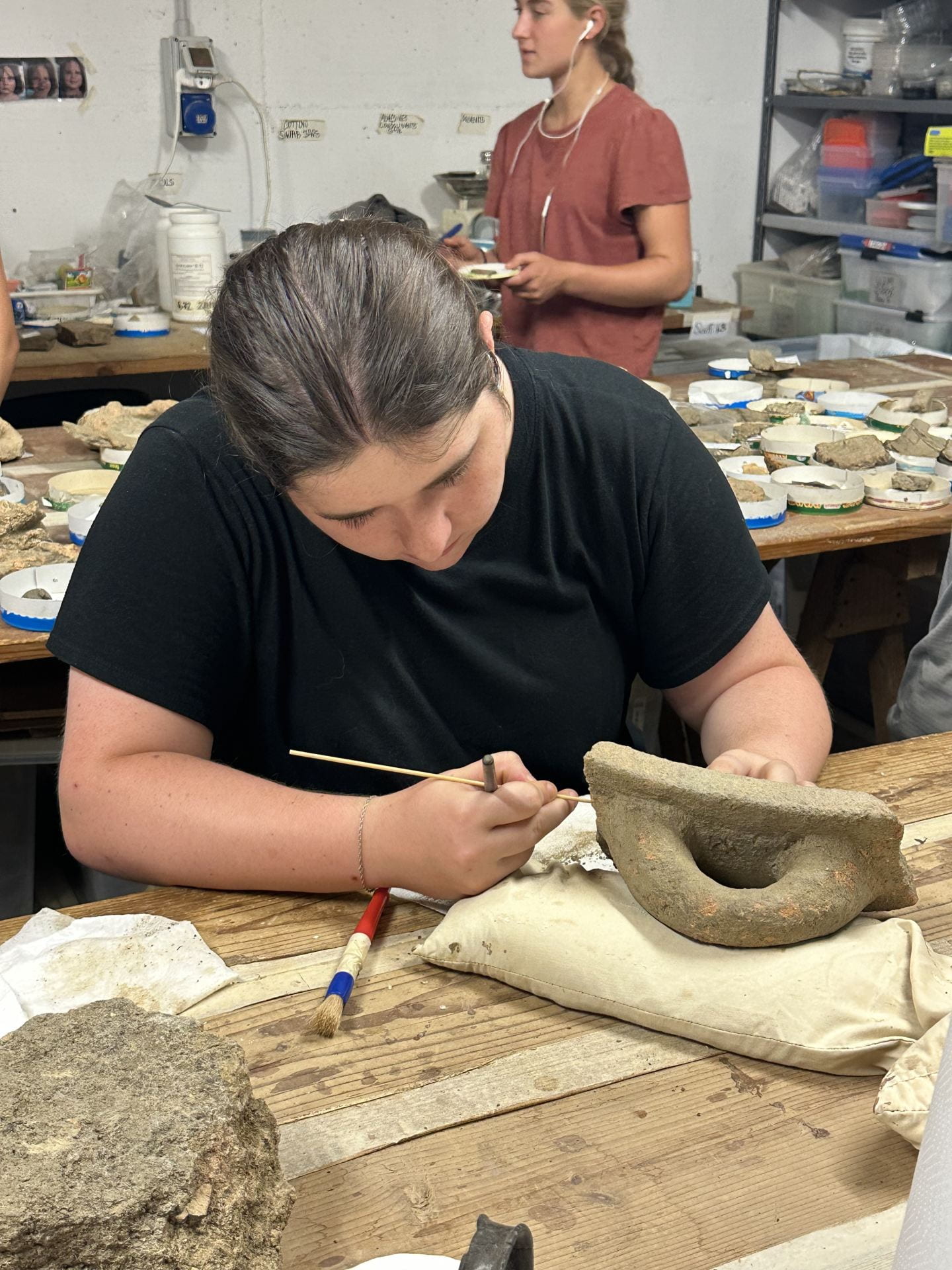 archaeological field school student, working on a find in a lab